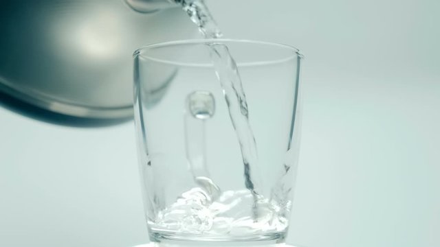 Pour Boiling Water Into A Glass Cup, Put A Spoonful Of Granulated Coffee, Stir, Put A Spoonful Of Sugar, Stir, Pour Milk And Pick Up A Drink, On White Background. Closeup. The Camera Moves Around. Slo