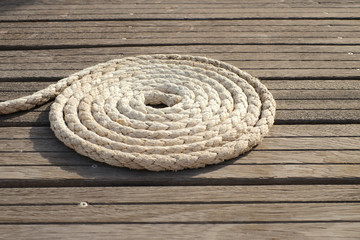 A coiled line on a wooden deck, perspective view.