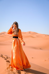 Fototapeta na wymiar A girl in a beautiful Moroccan dress. Merzouga Morocco.