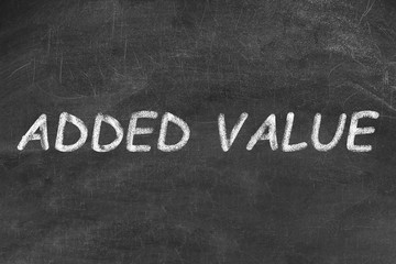 Obraz premium Phrase ADDED VALUE written on black chalkboard
