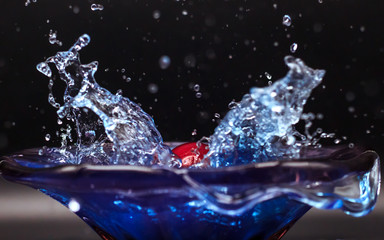 Apple thru in blue water, splash out of dish