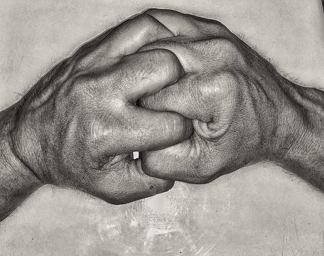 Close-up Of Interlocked Fingers On Table