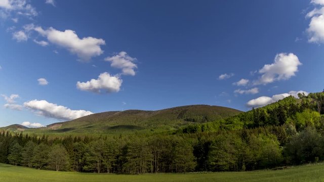 Timelapse of shadows and clouds moving on slopes of Radhost Hill overlooking a broadcast tower in a dense forest with moving shadows reflecting the sun from the advancing clouds Beskydy Park area.