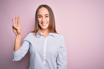 Young beautiful businesswoman wearing elegant shirt standing over isolated pink background showing and pointing up with fingers number three while smiling confident and happy.