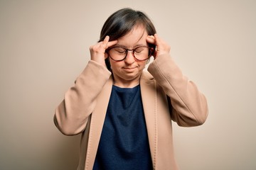 Young down syndrome business woman wearing glasses standing over isolated background with hand on head for pain in head because stress. Suffering migraine.