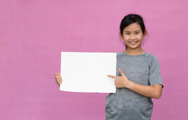 Little asian girl holding white paper isolated on pink background.