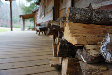 Logs Stacked Agains a Cabin