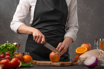 Chef cuts apples for cooking a duck or chicken. Recipe book, home recipes
