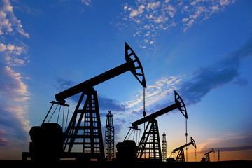 Silhouettes of crude oil pumps at sunset