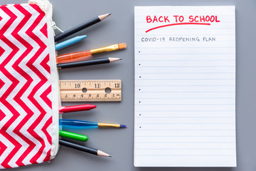 Back to school COVID-19 school reopening plan concept shot. Flay lay arrangement with school supplies