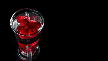 
Raspberries in a water glass. Free entry space.