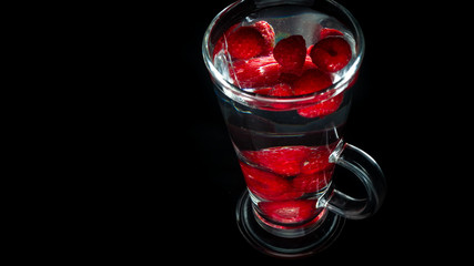 
Raspberries in a water glass. Free entry space.