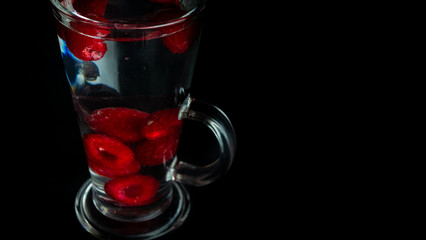 
Raspberries in a water glass. Free entry space.