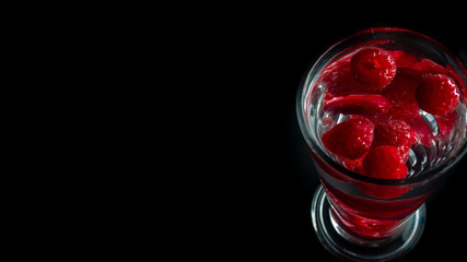 
Raspberries in a water glass. Free entry space.