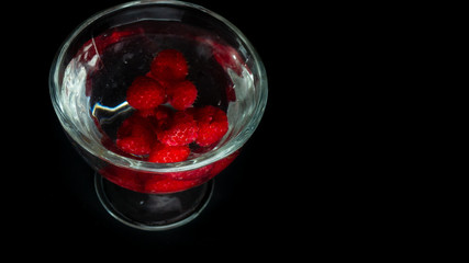 
Raspberries in a water glass. Free entry space.