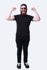Full length photo amazed bearded man celebrating victory over white