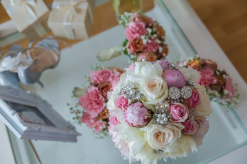 the bridal bouquet of a white and pink flowers with crystal and pearl jewelry