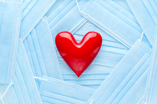 Bright Red Heart On A Pile Of Medical Face Masks. Concept Of Support, Love, Care And A Thank You To The Frontline Essential Workers And Healthcare Workers.