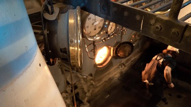 A still overhead shot of a man shoveling coal aboard the TSS Earnslaw. The ship currently resides in Queenstown, New Zealand.