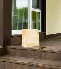 Paper bag, contactless delivery. On the stairs next to the house. The courier left an online order...