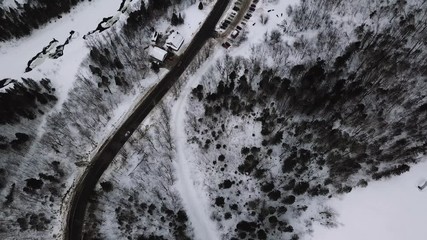 Aerial shot of a winter road in l'Anse St-Jean, Saguenay revealing the gorgeous Cove of Saint John in Quebec, Canada - Powered by Adobe