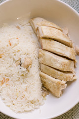 Hainanese Chicken Rice Served in a Bowl. The Poached Chicken is Served with Fried Chicken Rice. This is a traditional Chinese dish. 