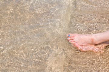 Women's feet that are nailed in sea
