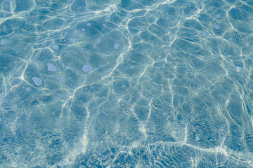 Blue pool water with sun reflections