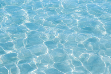 Naklejka na ściany i meble Blue pool water with sun reflections
