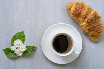 Cup coffee with croissant  on white table.