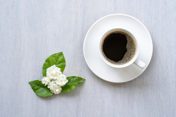 Cup coffee, jasmine flower  on white table.