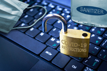 Unlocking COVID-19 restrictions in the New Normal as illustrated by an unlocked padlock with hand...