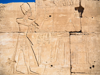 Egyptian legends on ruined wall, close up view. Ancient ruined wall in Karnak temple. Photographed in Luxor, Egypt. Selective soft focus. Blurred background