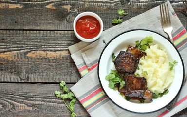 baked short ribs with mashed potatoes.
long stewed meat. rustic style, wooden table, top view, copy space