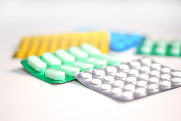 Colorful Many pills and tablets isolated on white background, pharmaceuticals antibiotic drug capsule pills in package.
