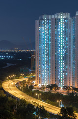 High rise residential building and highway in Hong Kong city at night