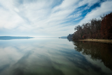 Fototapeta premium Peaceful Winter Day at the Beach. Reflection of cloudy Sky in the Water