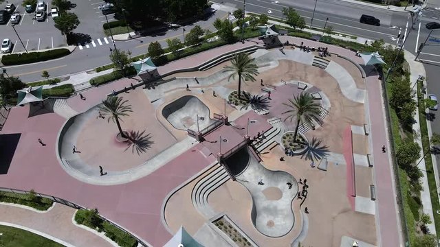 Aerial orbit view, skate park of young kids riding bikes and skateboards