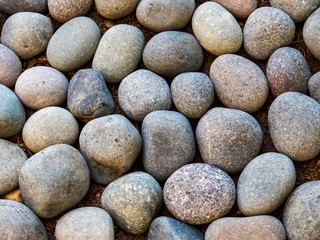 Fototapeta na wymiar Mineral Background: Round pebbles close-up photo with different shapes and forms.