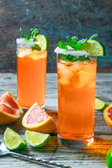 Paloma cocktail with grapefruit and lime in a dark background.