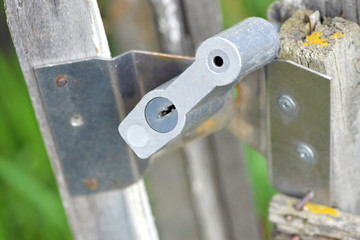 Old lock in a wooden gate, close-up: a key hole