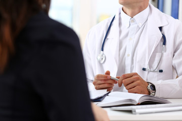 Male doctor hands hold silver pen discuss problem