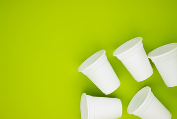 biodegradable beverage containers on a green background, space for text. environmental protection. caring for nature. the rejection of the plastic