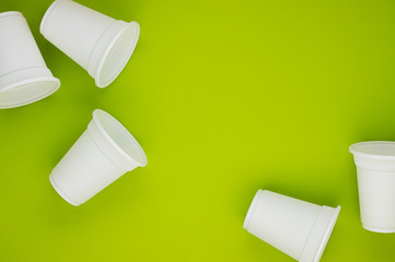 biodegradable beverage containers on a green background, space for text. environmental protection. caring for nature. the rejection of the plastic