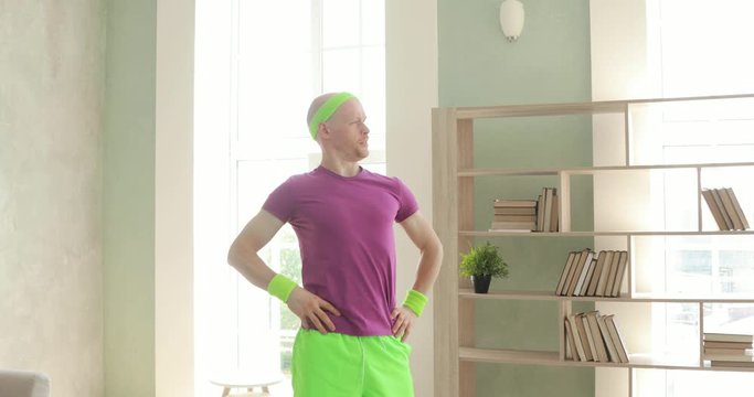 Confident funny man in sportswear and showing thumb up on camera at home. Vainy blogger vlogger making content for his blog vlog. Sportive humor, joke, mem and fun concept. Making content.