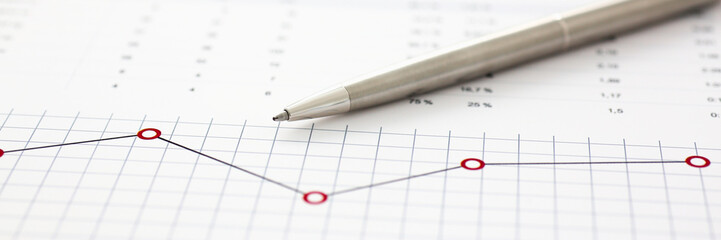 Financial statistics documents on clipboard pad at office table closeup