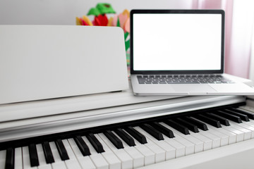 Fototapeta na wymiar a white piano with a laptop on it. remote training, online education
