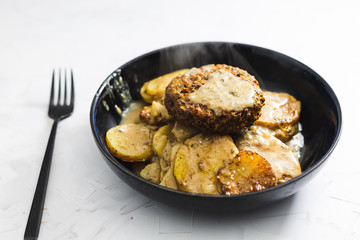 plant-based food, vegan scalloped potato bake with pumpking burger and dairy-free cheese