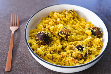 plant-based food, vegan turmeric couscous with falafels onions and chopped tomatoes