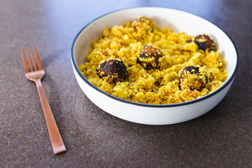 plant-based food, vegan turmeric couscous with falafels onions and chopped tomatoes